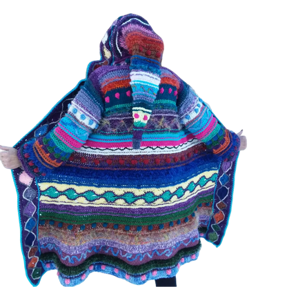 A woman wearing a colorful crochet hooded coat.