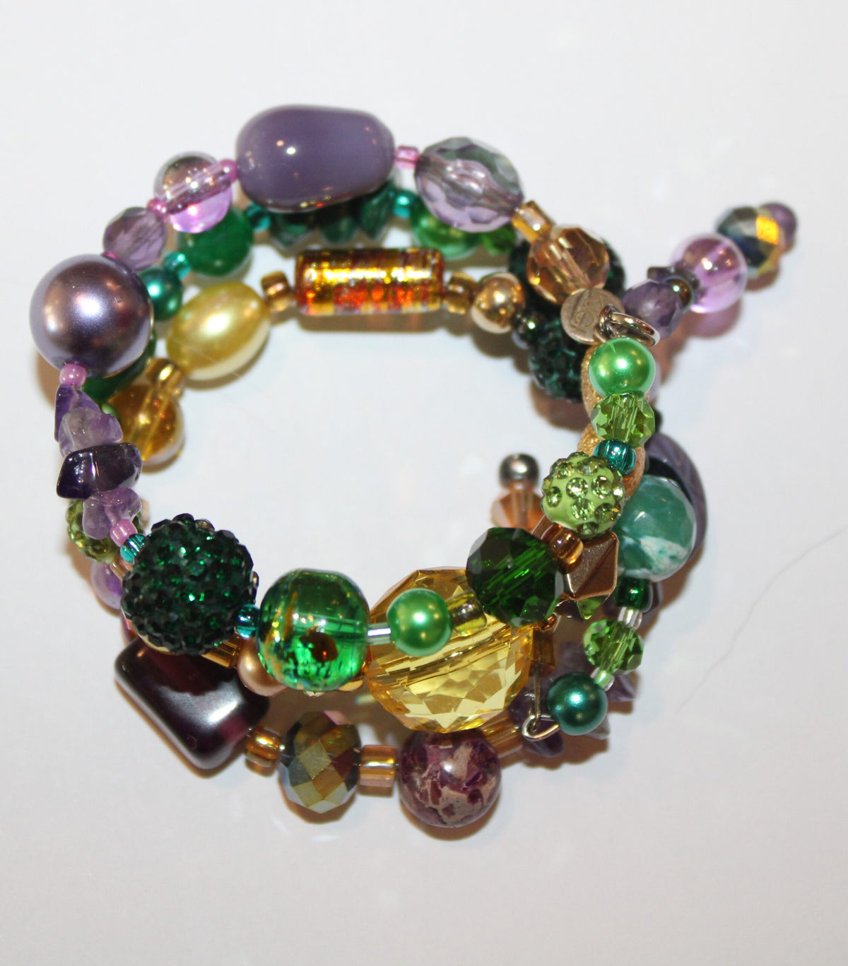 A bracelet with green, purple, and yellow beads.