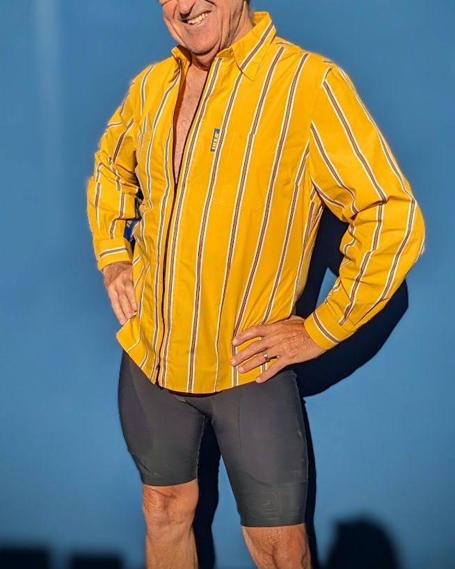 A man wearing a yellow striped shirt and shorts.