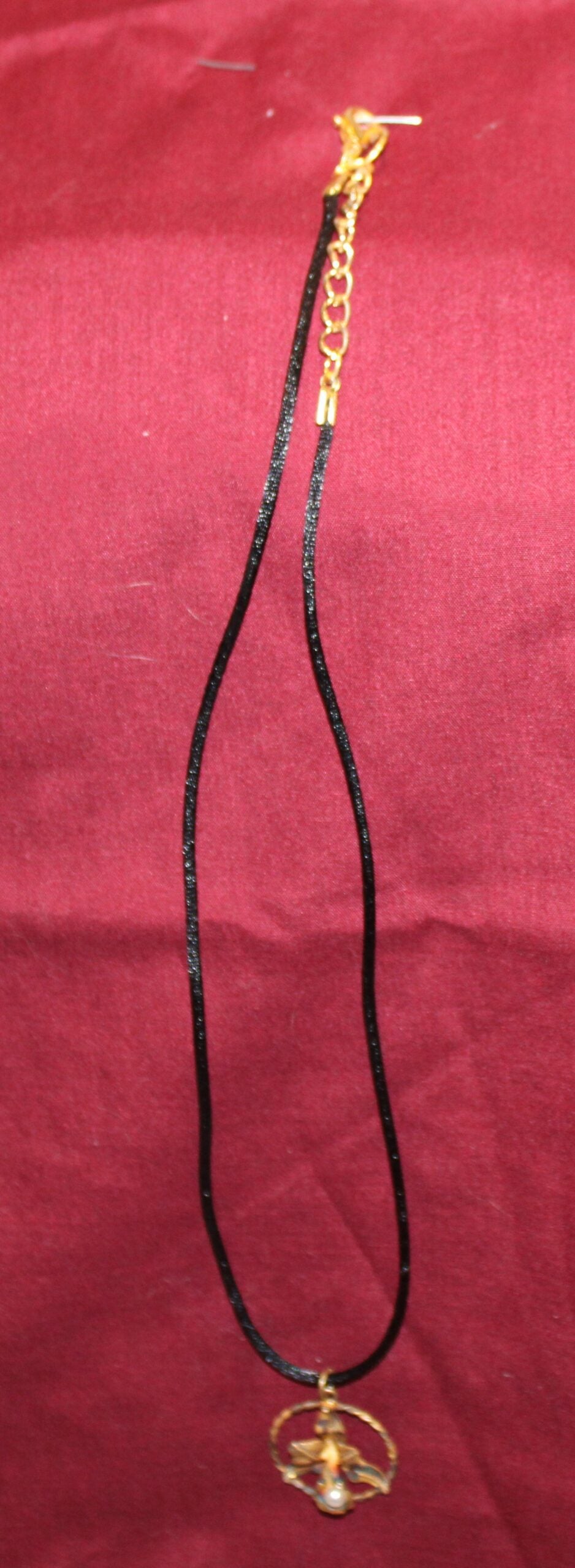 An antique orchid gold-tone pendant with a new silk cord necklace.