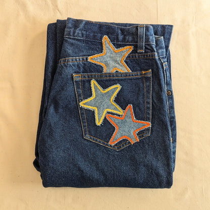 A pair of jeans with stars embroidered on them.