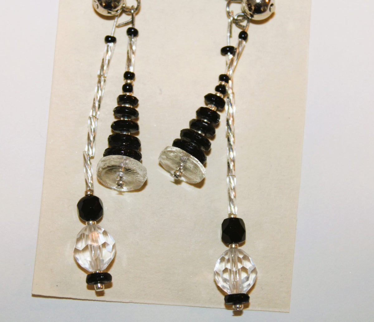 A pair of earrings with black and clear beads.