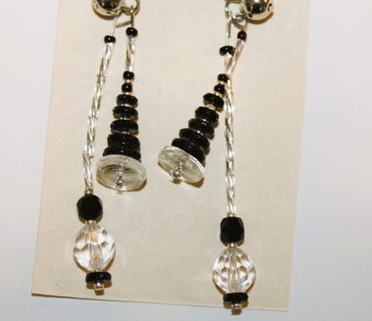 A pair of earrings with black and clear beads.