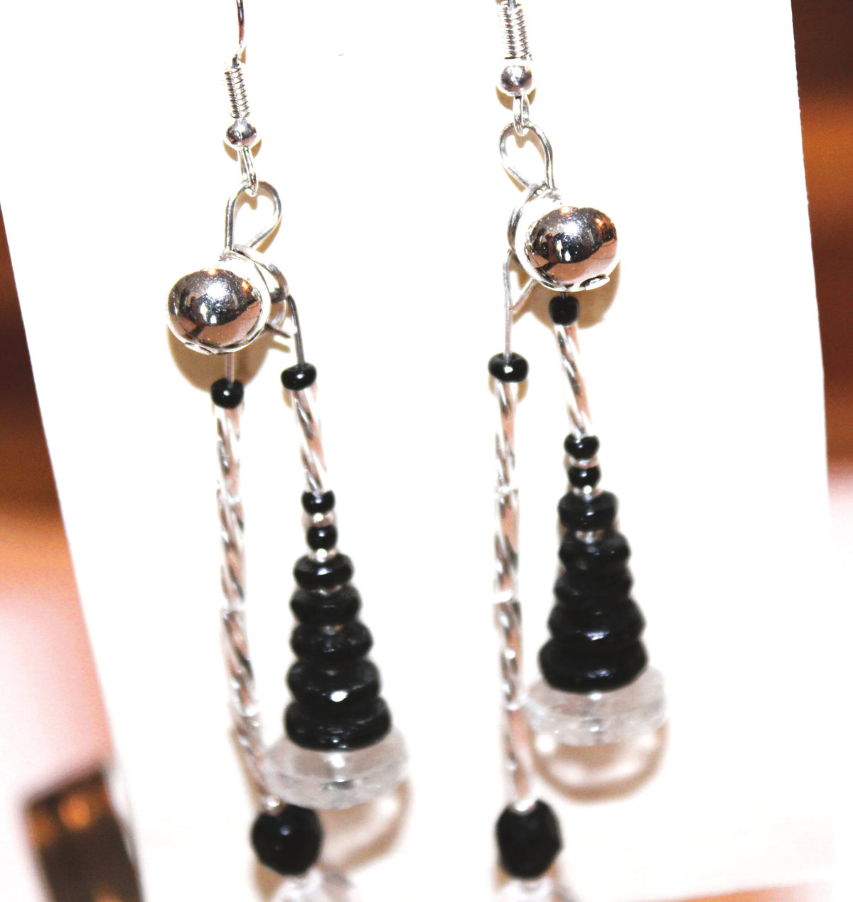 A pair of black and white dangling earrings.