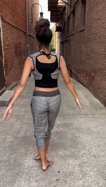 A woman walking down an alley with her back to the camera.