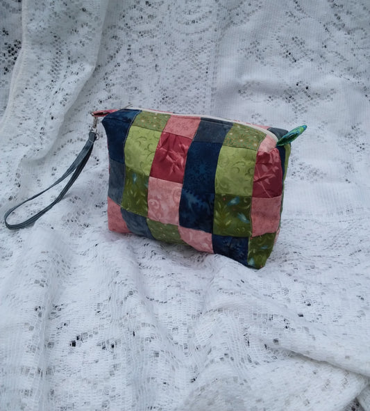 A colorful quilted pouch on a white lace doily.