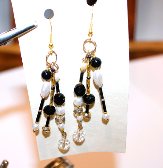 A pair of earrings with black and white beads.