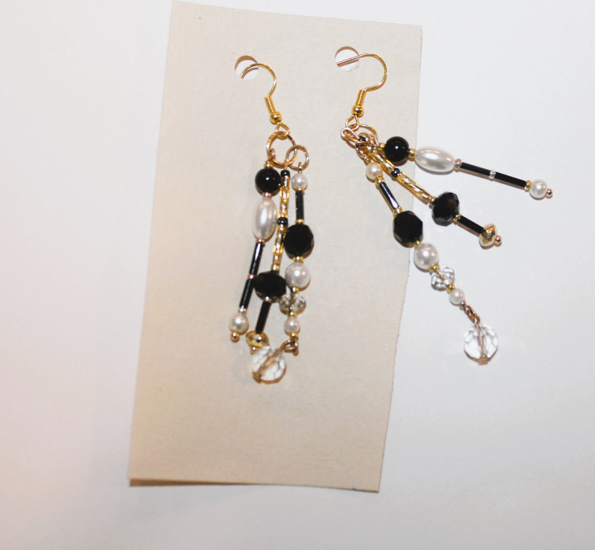 A pair of black and white earrings on a piece of paper.