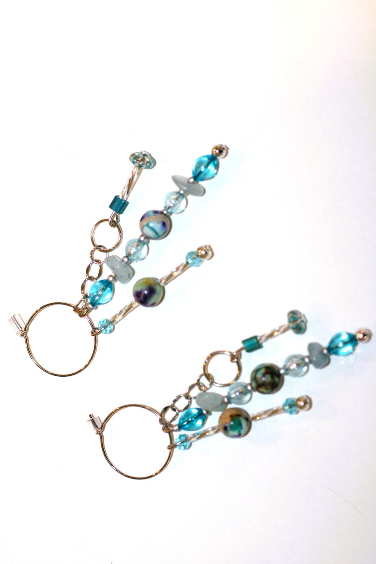 A pair of earrings with blue glass beads on them.