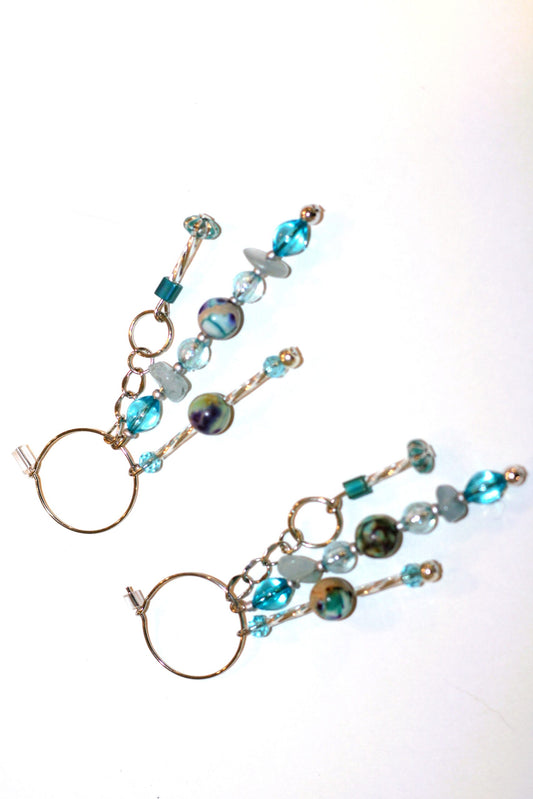 A pair of earrings with blue glass beads on them.