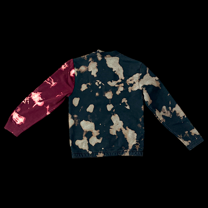 A black and burgundy tie dyed sweatshirt on a black background.