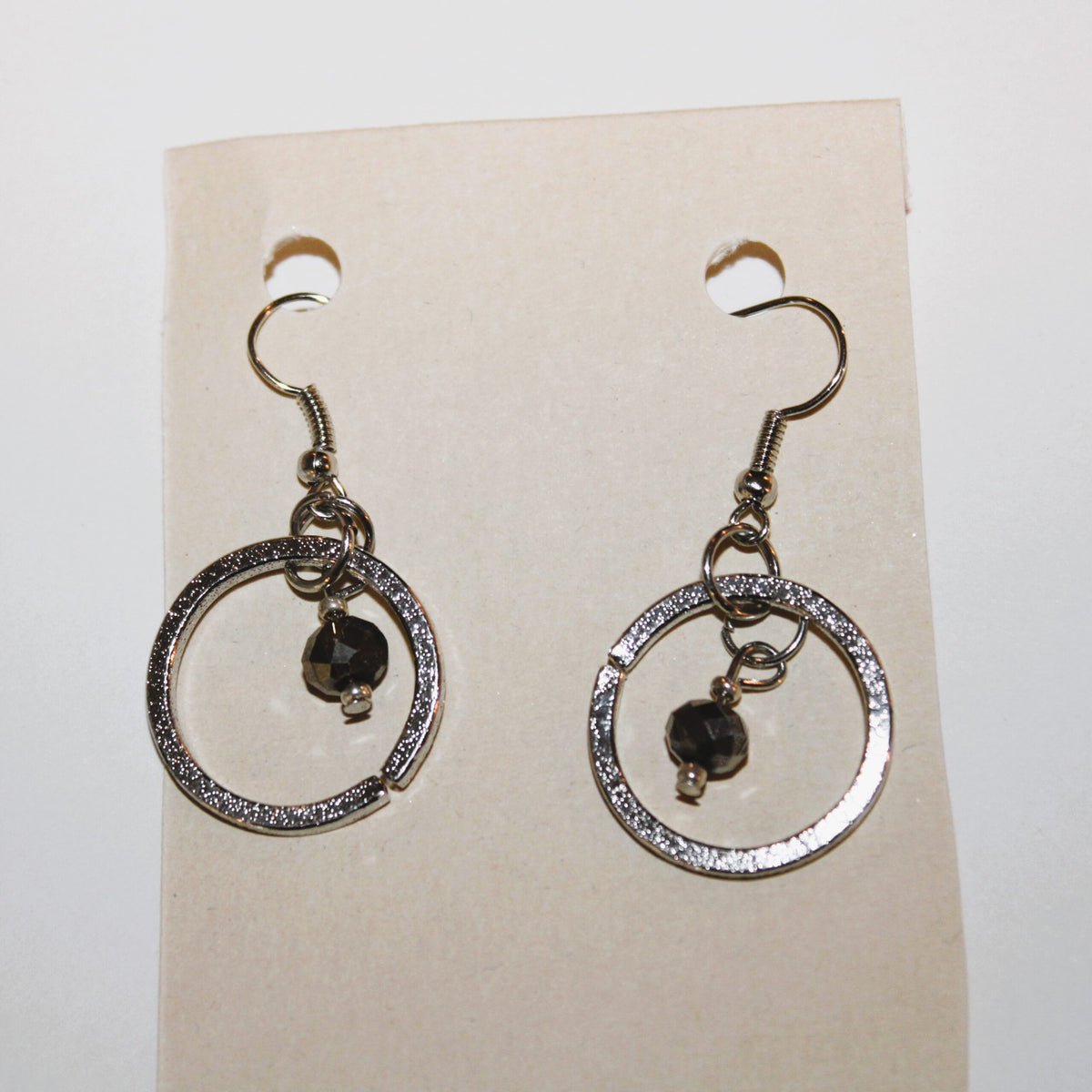 A pair of silver dangle earrings with black stones.