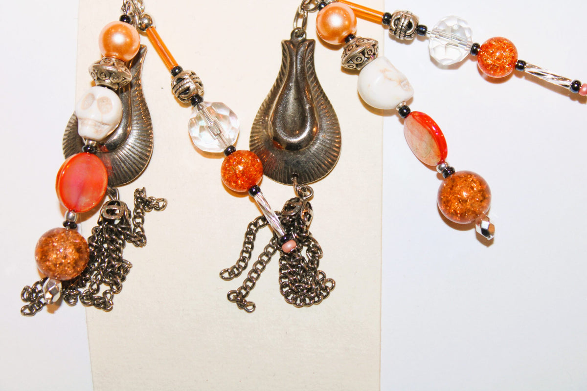 A pair of earrings with tassels hanging from them.
