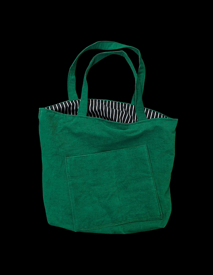 A green tote bag on a black background.