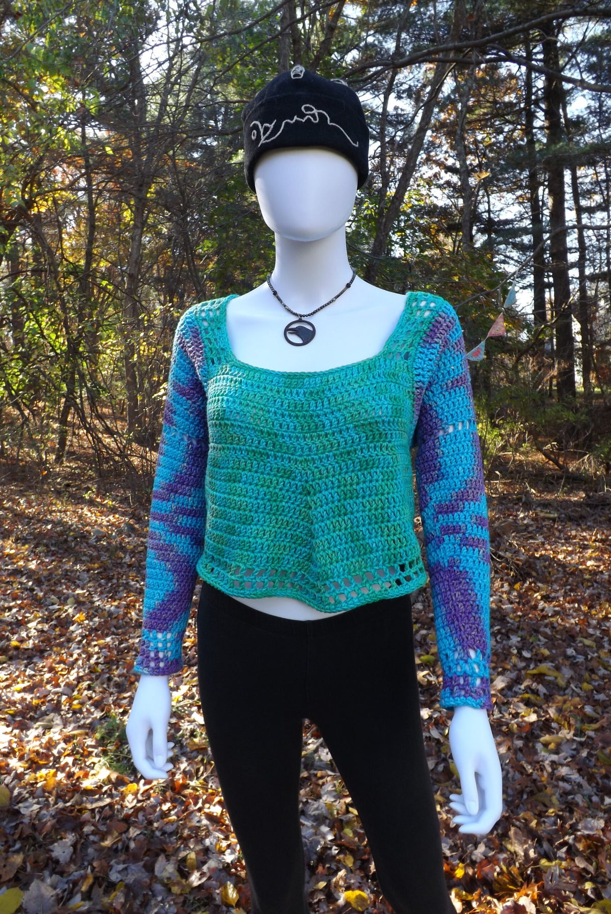 A cropped crochet sweater with long sleeves.