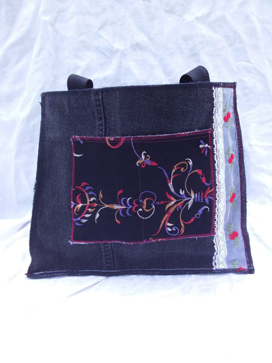 A denim tote bag with embroidery on it.