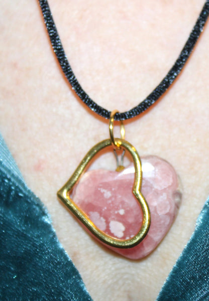 View of two heart shaped pendants on silk cord on neck