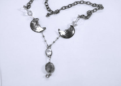 A silver necklace with a moon and stars on it.