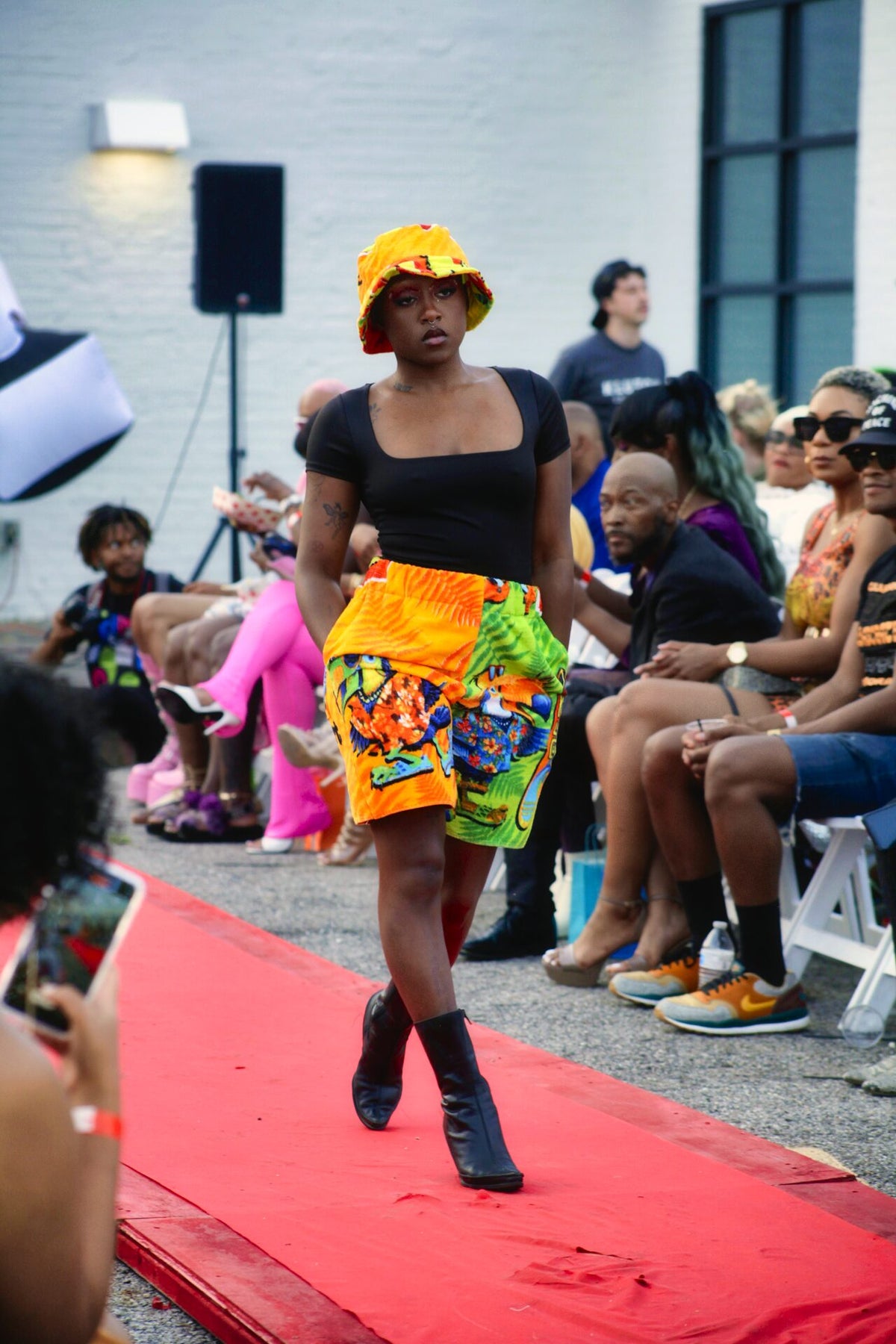 a black woman walking down the runway at a fashion show.