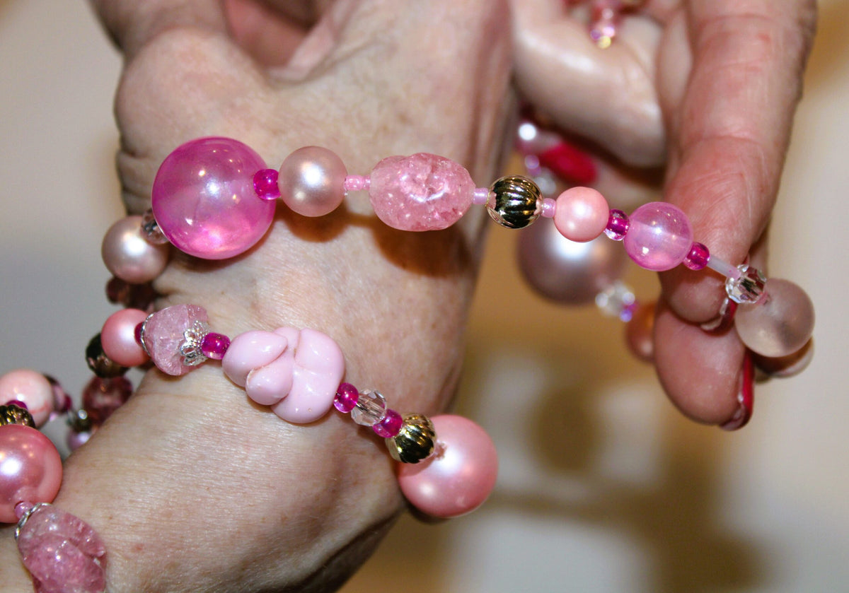 view of pink beaded wrap bracelet being put on wrist