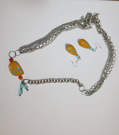 A necklace and earrings are sitting on a table.
