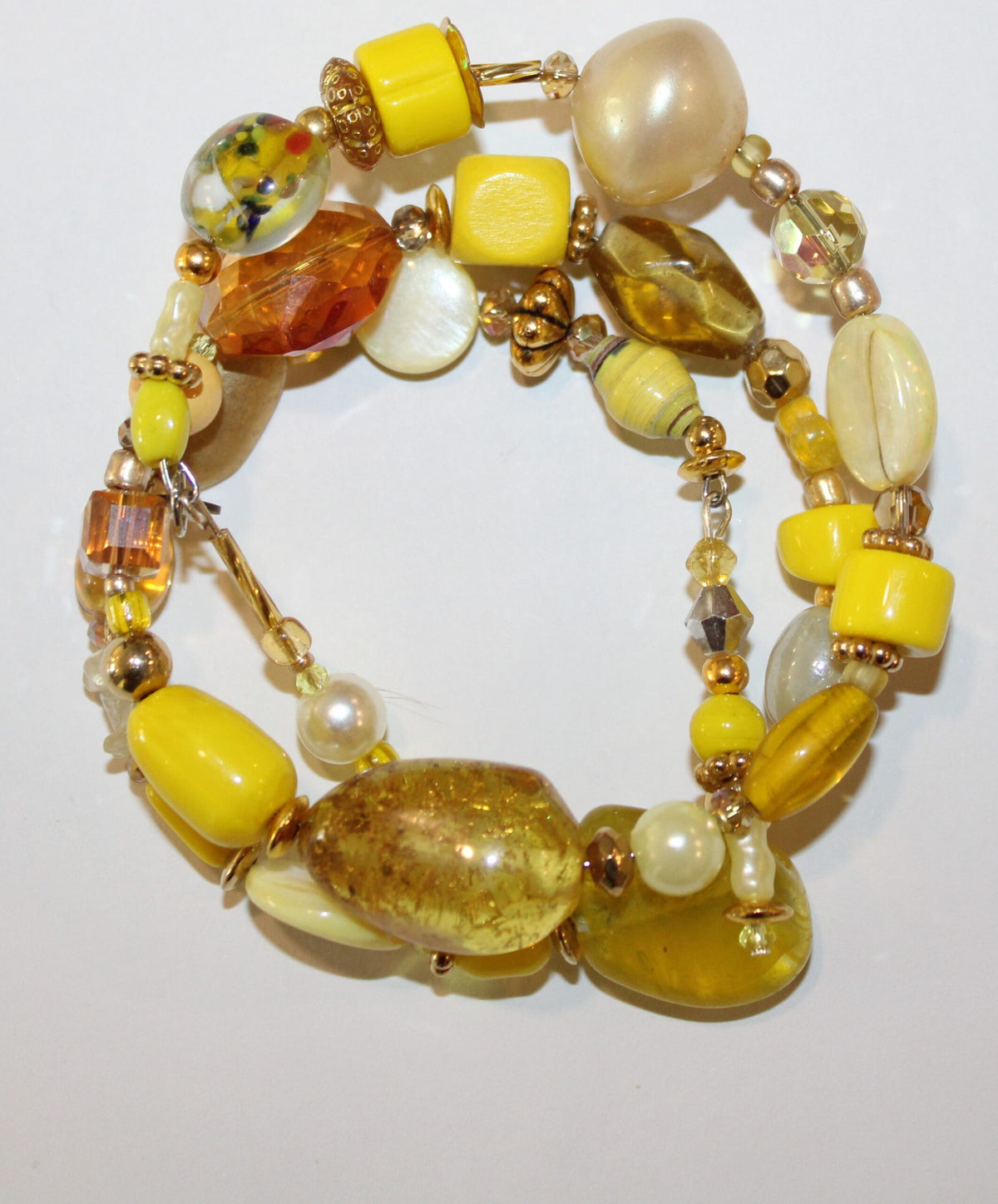A yellow beaded bracelet with pearls and glass beads.