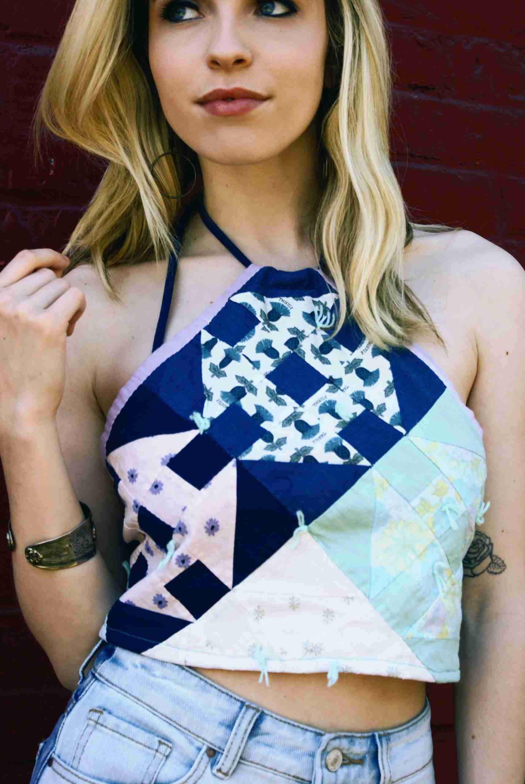 a woman wearing a top with a patchwork design on it.
