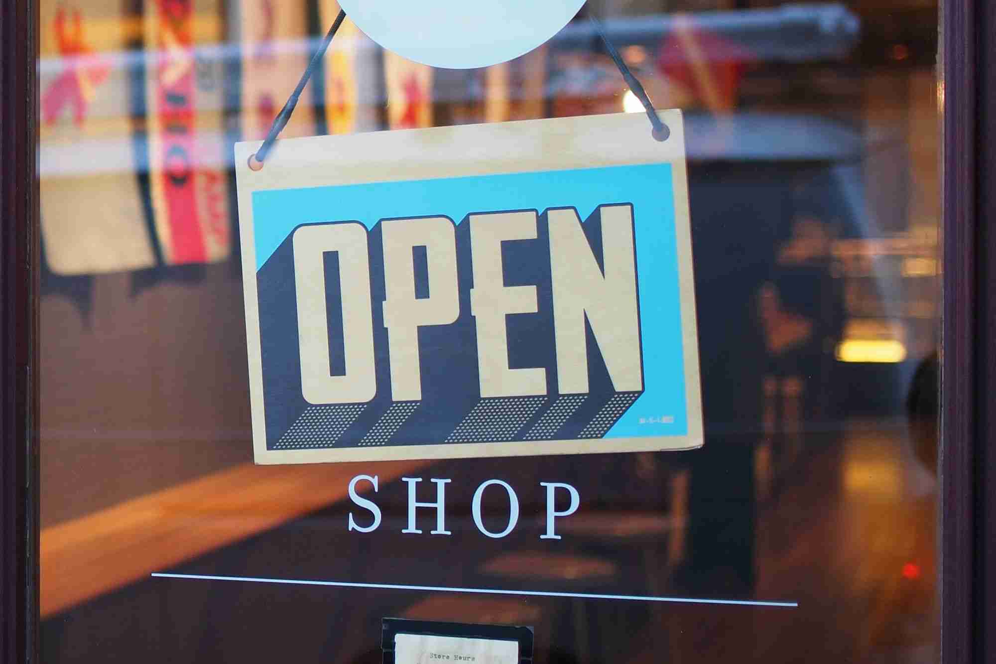 a sign on a store window that says open shop.