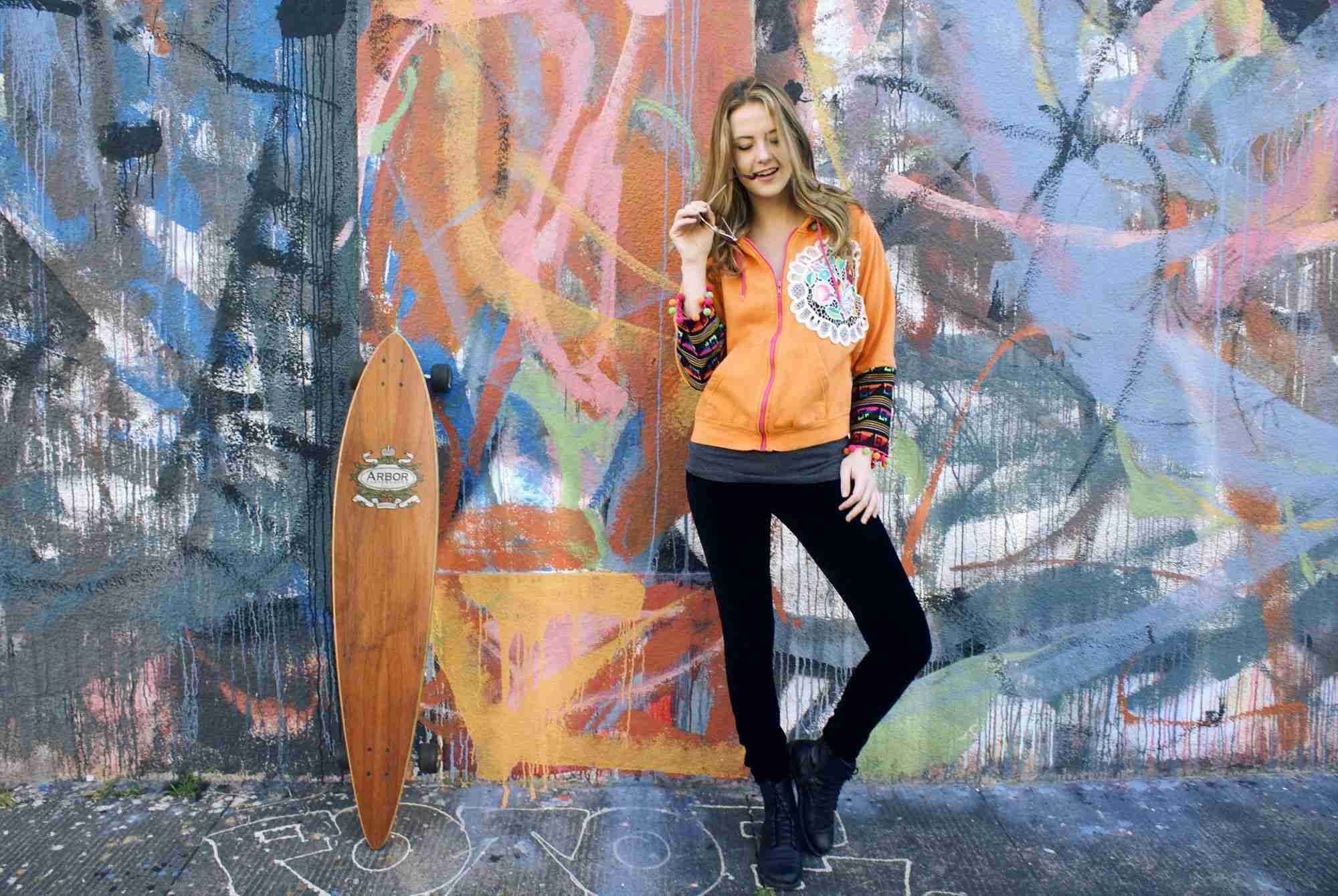 a woman standing in front of a wall covered in graffiti.