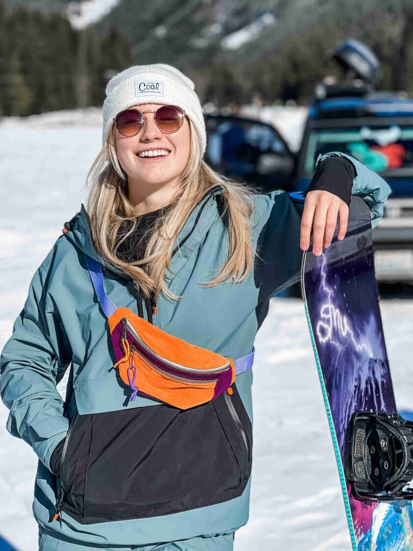 a woman holding a snowboard in the snow.
