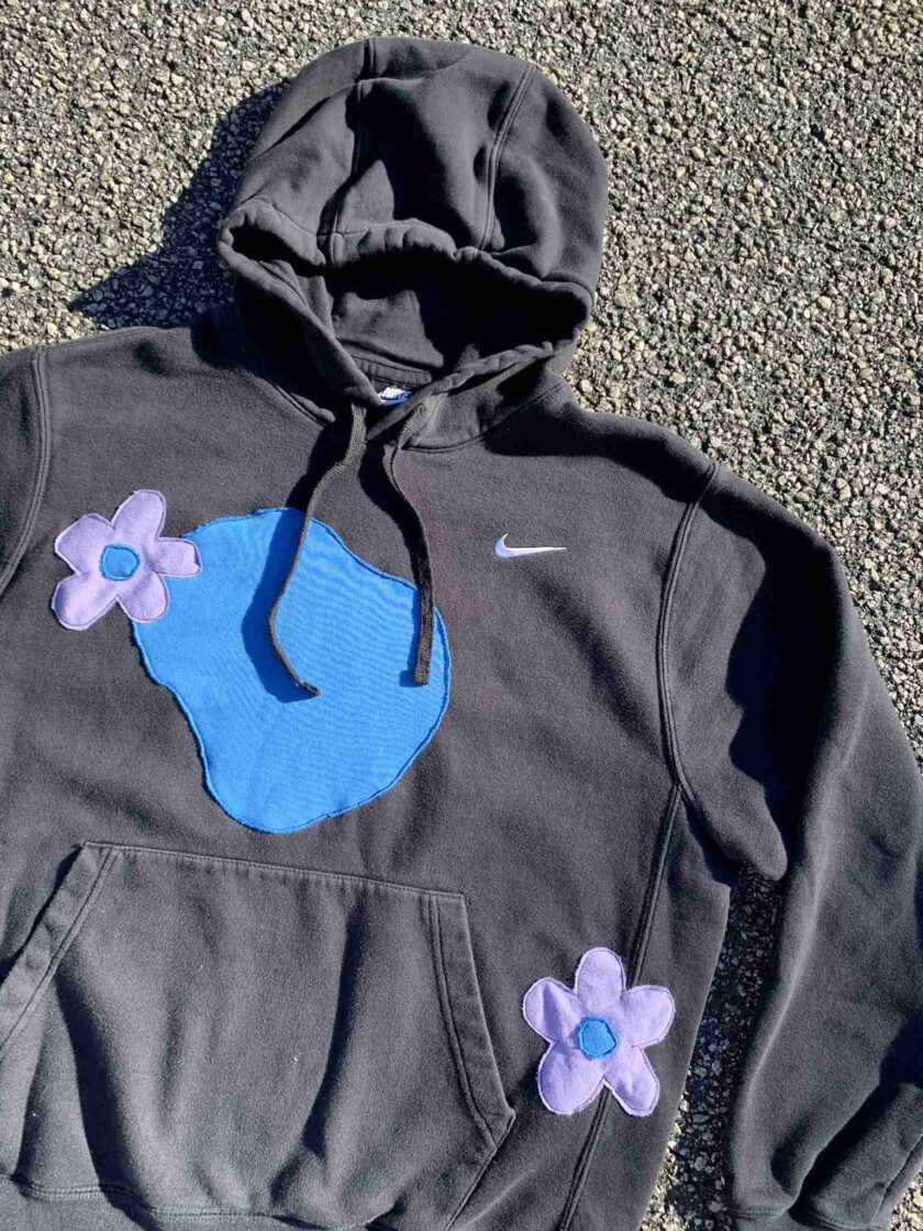 a gray hoodie with blue and purple flowers on it.