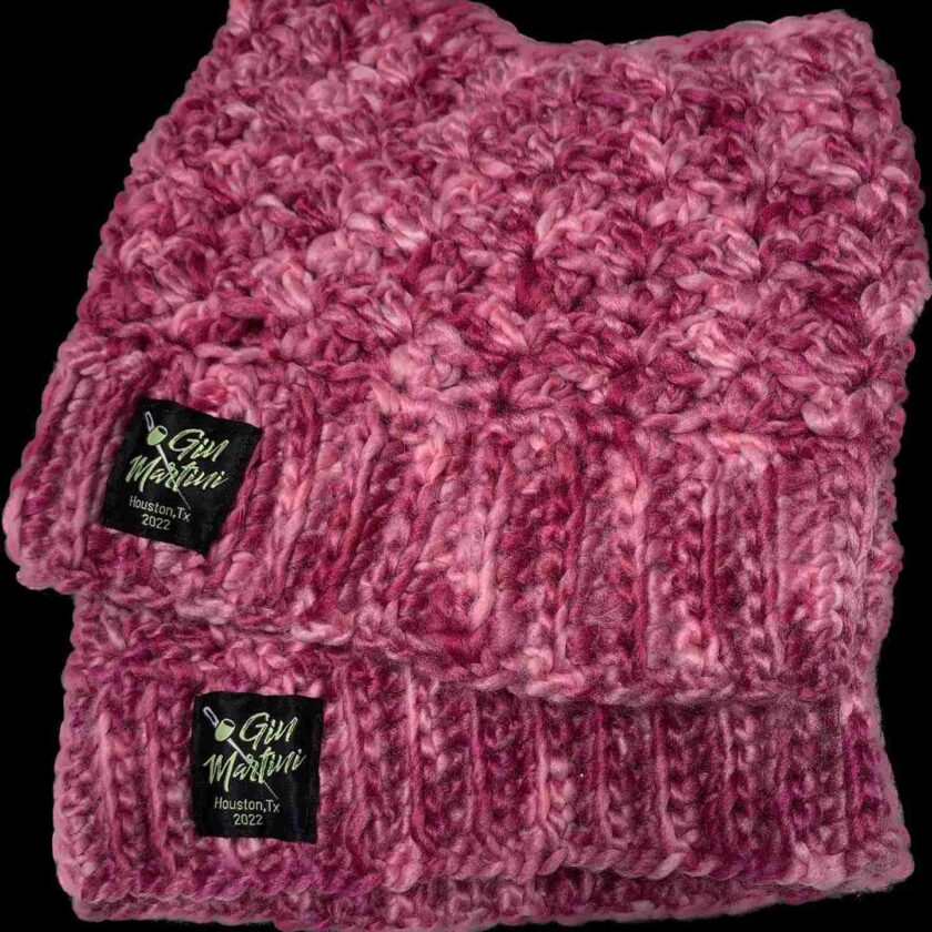 a close up of a knitted hat on a black background.