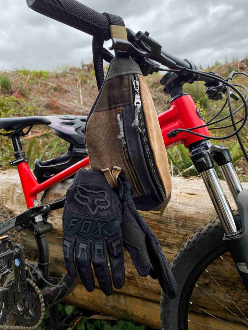 a pair of gloves hanging from a bicycle handlebar.