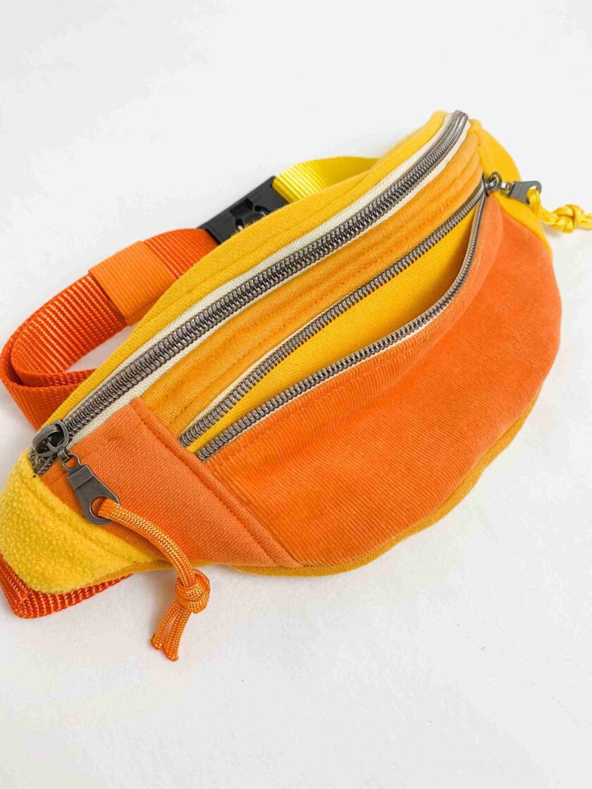 an orange and yellow fanny bag with zippers.