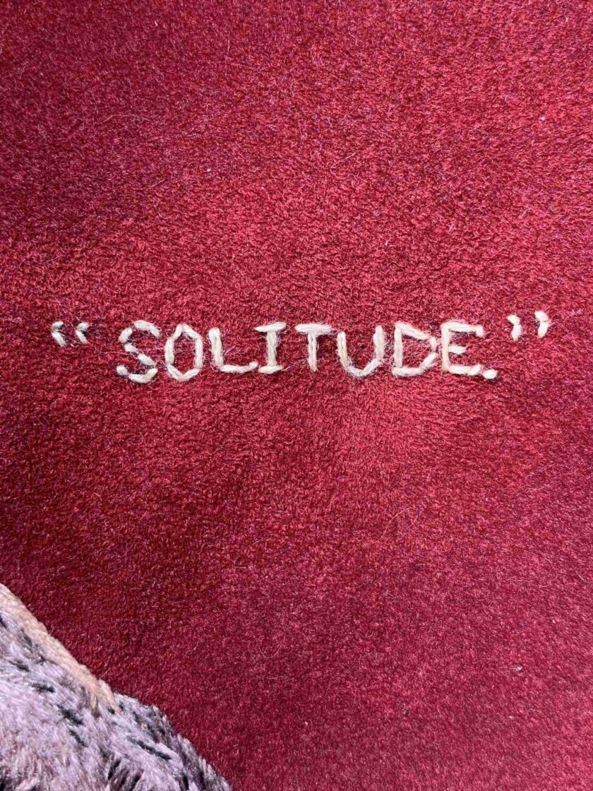the word solitude written on a red carpet.