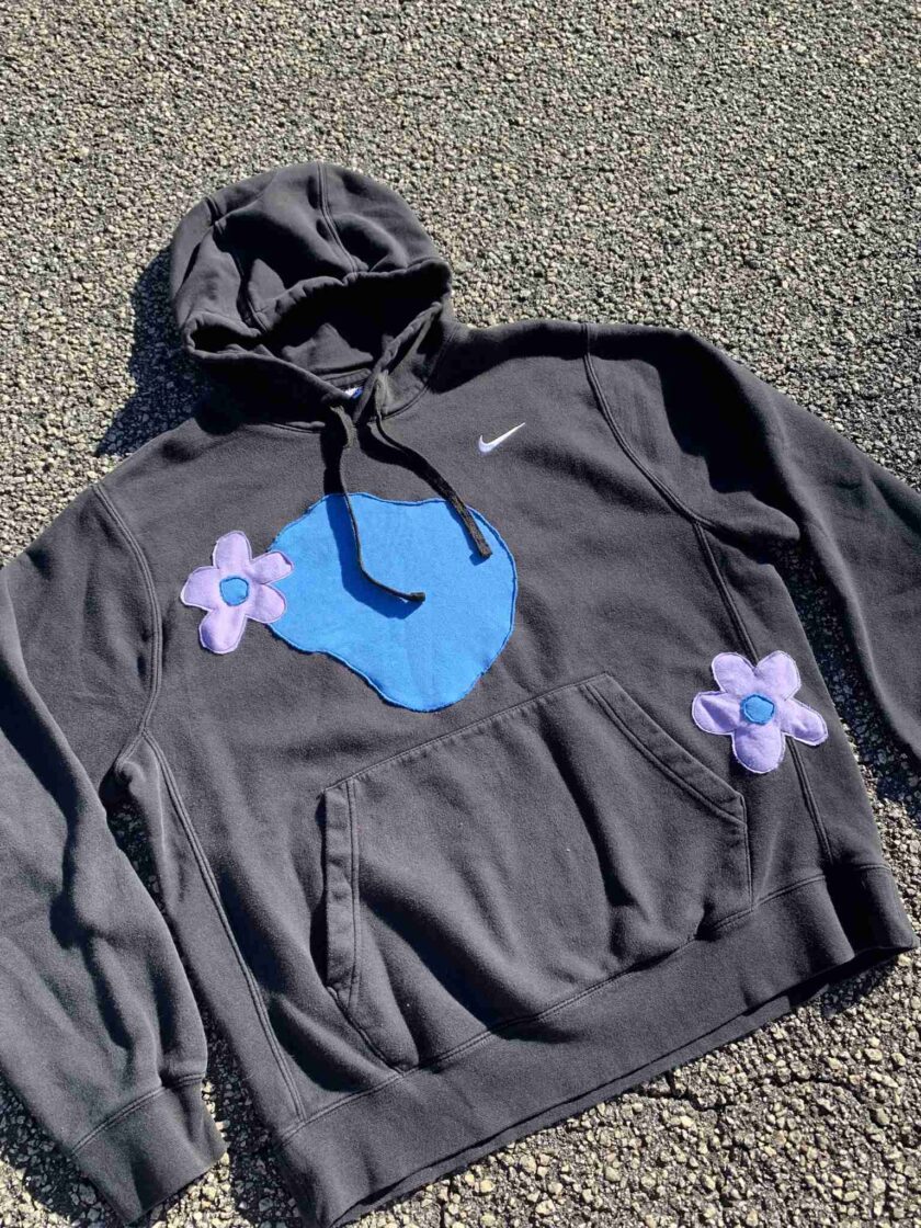 a black hoodie with a blue whale on it.