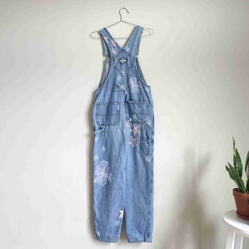 a pair of blue denim overalls hanging on a wall.