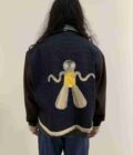 a person wearing a jacket with a picture of a mosquito on it.