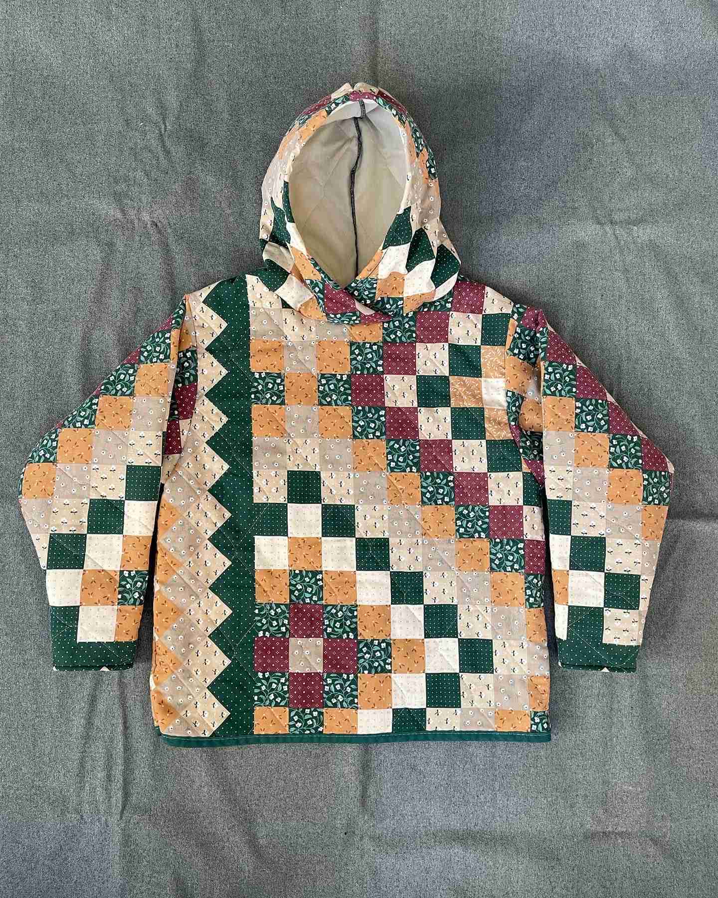 a green, orange, and white jacket with a hood.