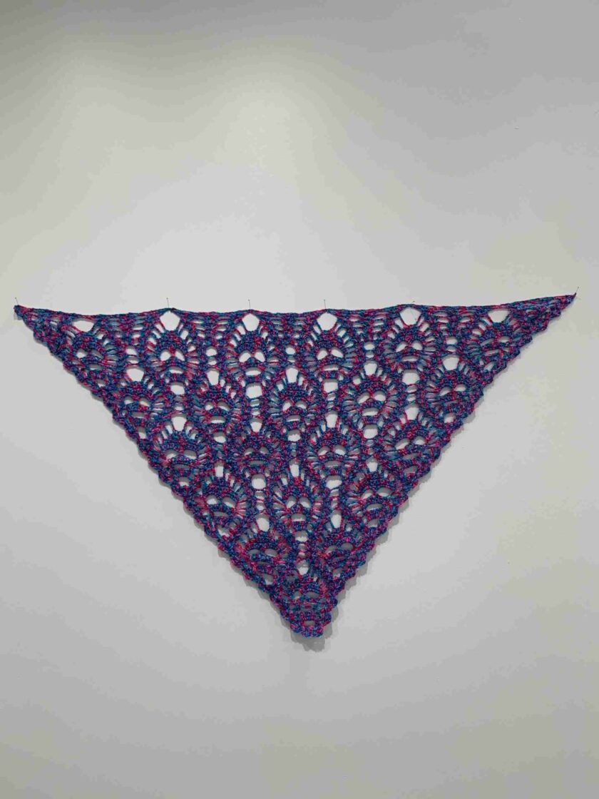 a purple and blue triangle shaped object on a white wall.