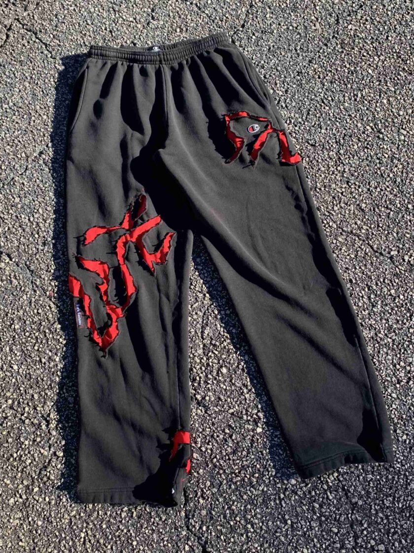 a pair of black pants with red laces on them.
