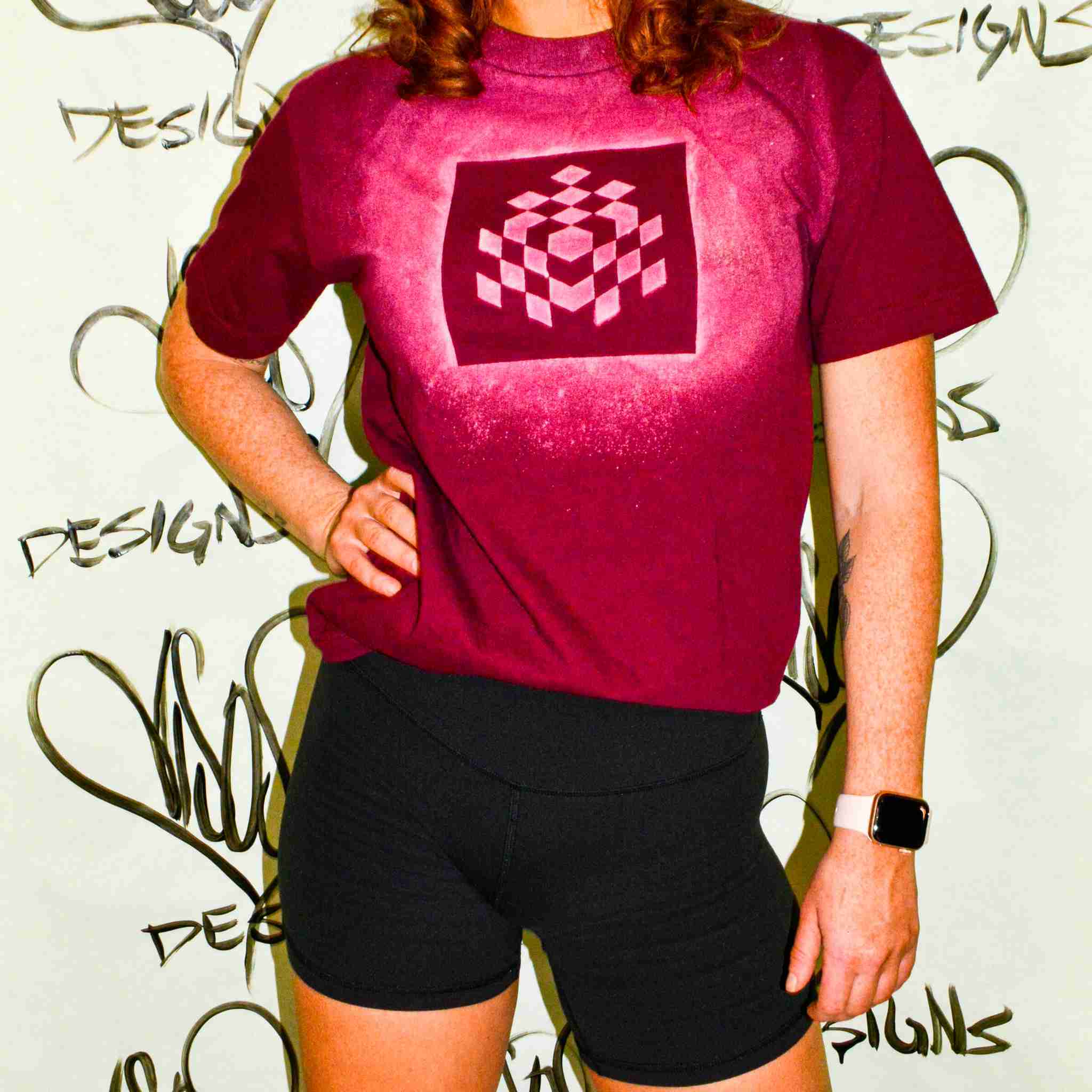a woman wearing a red shirt and black shorts.
