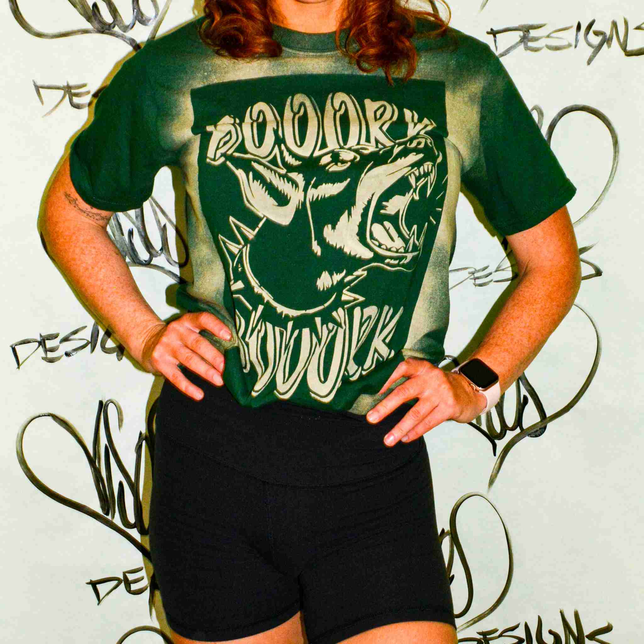 a woman wearing a green shirt and black shorts.