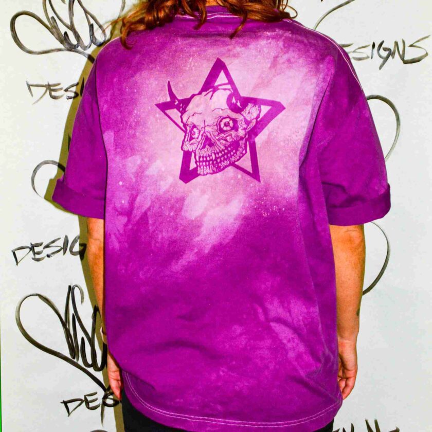 a man wearing a purple shirt with a skull and star on it.