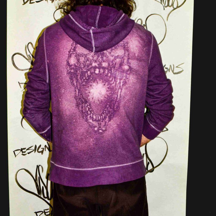 a person wearing a purple hoodie with a bear on it.