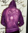 a person wearing a purple hoodie with a picture of a bear on it.
