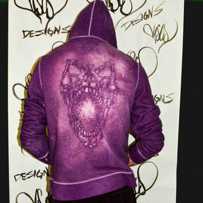 a person wearing a purple hoodie with a picture of a bear on it.
