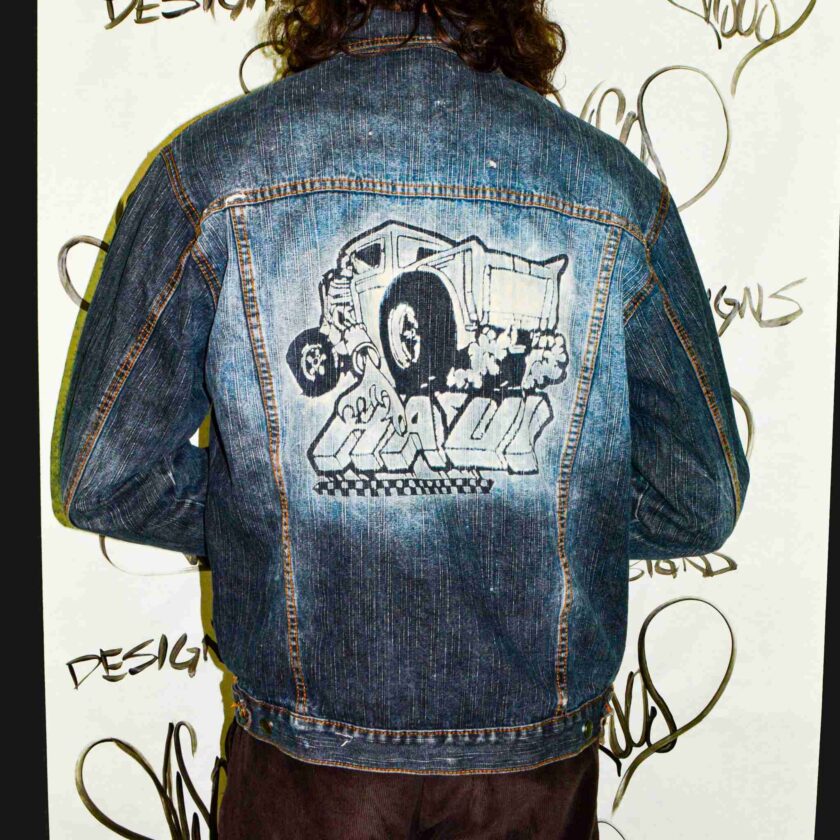 a man with long hair wearing a jean jacket.