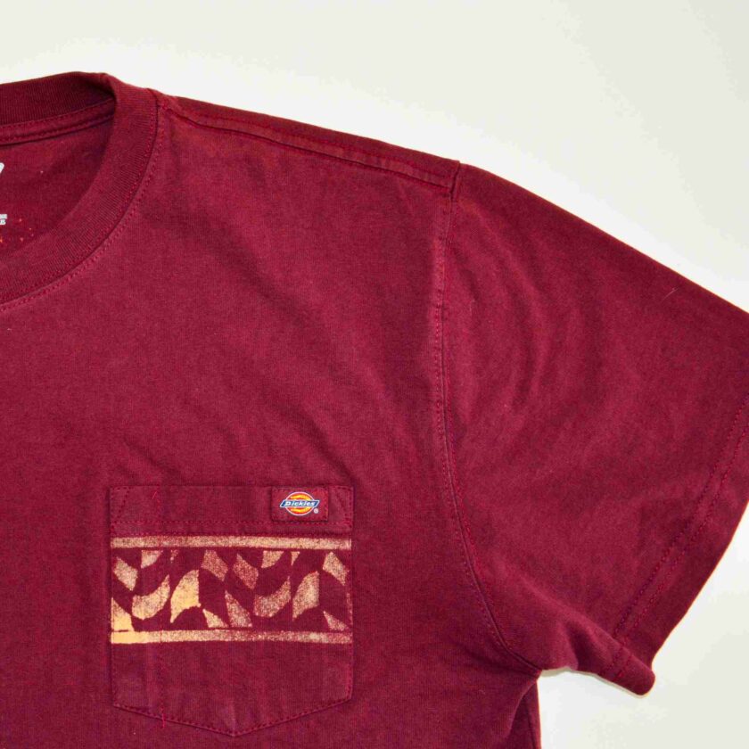 a red t - shirt with a pocket on it.