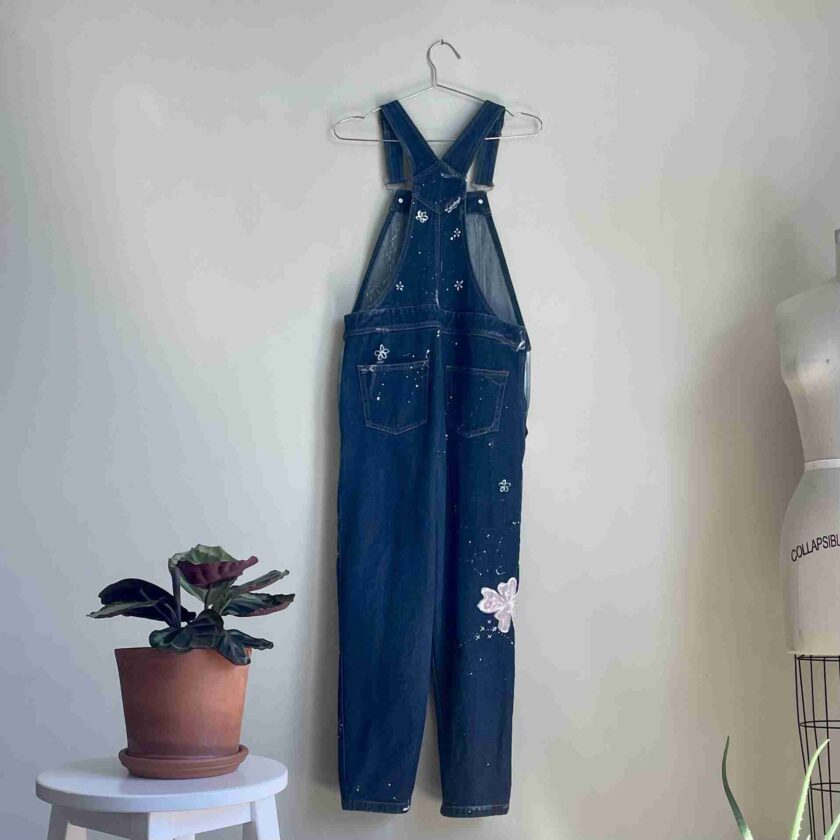 a pair of denim overalls hanging on a wall.